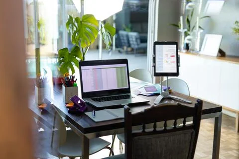 Notepad, laptop and tablet with spreadsheet and document on screen, on dining Stock Photos