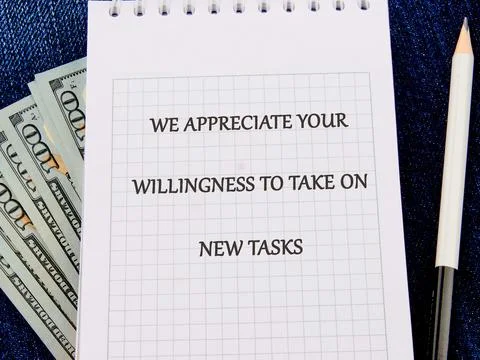 A notepad lays on a textured background displaying a motivational message a.. Stock Photos