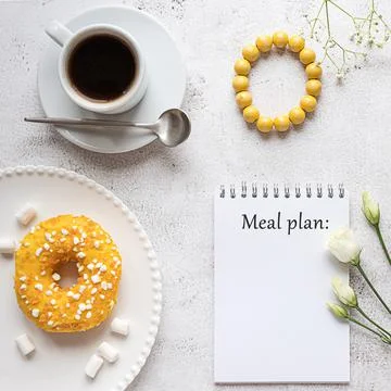 A notepad for meal planning with breakfast setting and ladies accessories Stock-Fotos