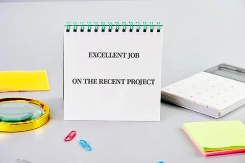 A notepad with the message excellent job on the recent project is positioned  Stock Photos