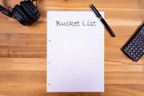 A notepad with a note saying "Bucket List" together with a pen, a calculator  Stock Photos