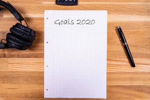 A notepad with a note saying "Goals 2020" together with a pen, a calculator a Stock Photos