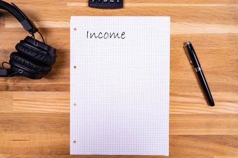 A notepad with a note saying "Income" together with a pen, a calculator and h Stock Photos