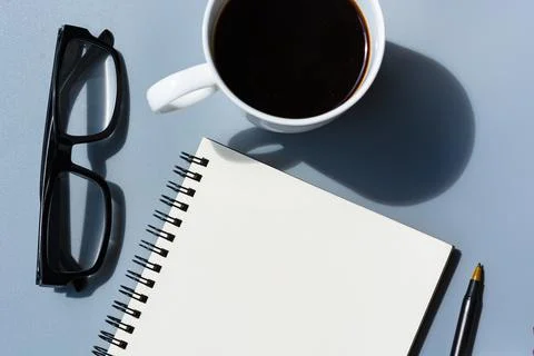 Notepad with notepad, potted plant, pen and glasses. Flat lay. Stock Photos