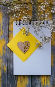 Notepad for notes and white flowers on a yellow background, top view Stock Photos