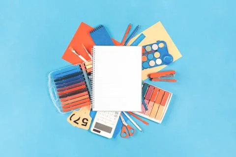Notepad over office and school stationery flat lay on aqua blue Stock Photos