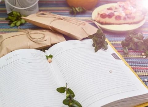 Notepad, paper envelope and piece of pie on the colorful tablecloth Stock Photos