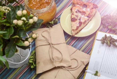 Notepad, paper envelope and piece of pie on the colorful tablecloth Stock Photos