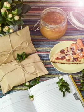 Notepad, paper envelope and piece of pie on the colorful tablecloth Stock Photos