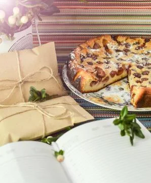 Notepad, paper envelope and piece of pie on the colorful tablecloth Stock Photos