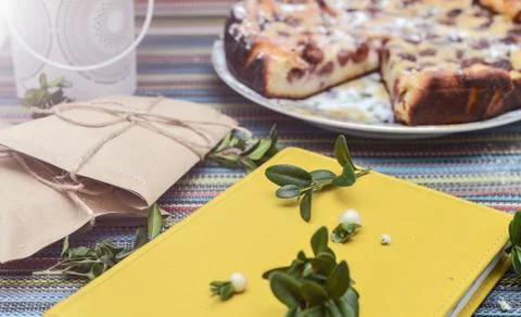 Notepad, paper envelope and piece of pie on the colorful tablecloth Stock Photos