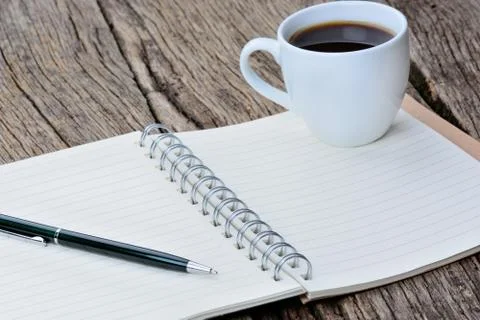 Notepad with pen and coffee cup on desk Stock Photos