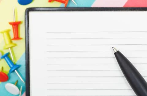 Notepad with pen and pushpins Foto stock