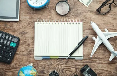 Notepad with pen and travel items on the wooden background. 写真素材