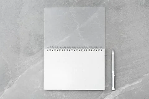 Notepad with a pen on a marble background. Stock Photos