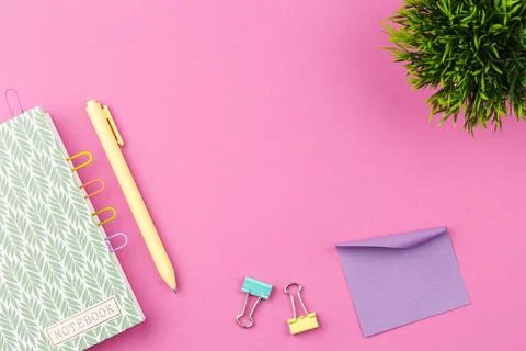 Notepad with pen on pink background. Stock Photos