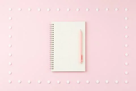 Notepad with pen on pink desk. Foto stock