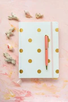 Notepad, pen, sea shells and corals on workspace Stock Photos