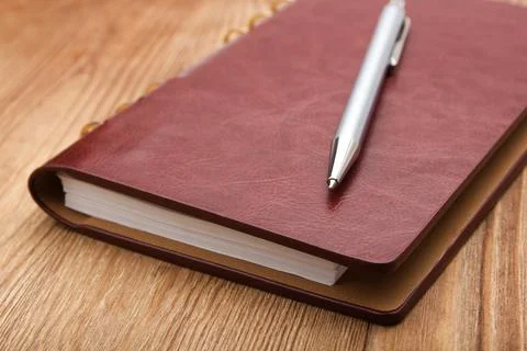 Notepad with pen on wood table Fotos de archivo