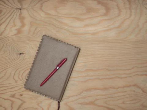 Notepad with a pen on a wooden table. Stock Photos