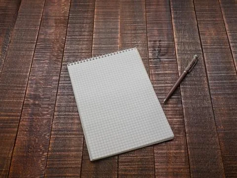 Notepad with a pen on a wooden table. Stock Photos