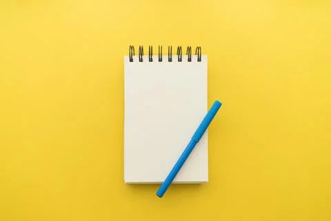 Notepad with pen yellow background. High quality and resolution beautiful photo Stock Photos
