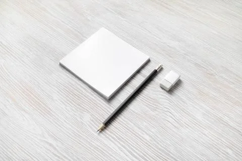 Notepad, pencil, eraser White square notepad, pencil and eraser on light w... Stock Photos