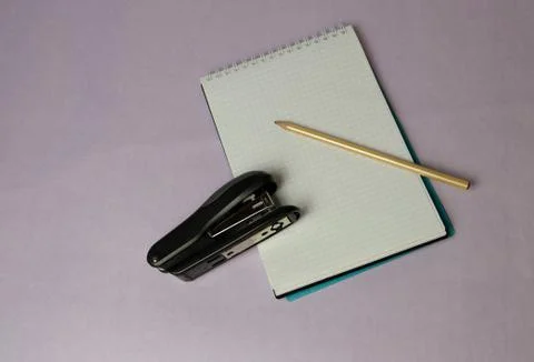 Notepad pencil stapler on lilac background Stock-Fotos