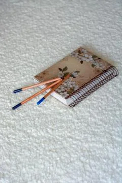 Notepad with pencil on a white blanket. Stock Photos