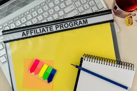 A notepad with a pencil on a yellow folder labelled "AFFILIATE PROGRAM" on a  Stock Photos