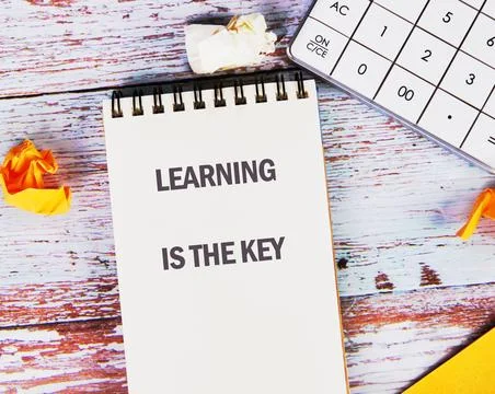 A notepad with the phrase learning is the key is surrounded by a calculator a Stock Photos