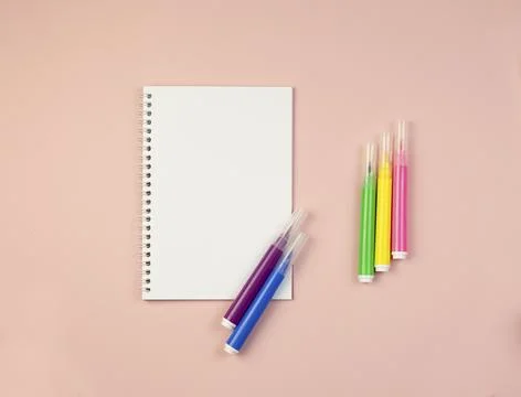 Notepad on a pink background with a backup for copy with multi colored markers Stock Photos