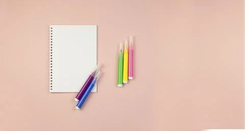 Notepad on a pink background with a backup for a copy with multi colored marker Stock Photos