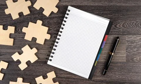 Notepad with puzzle pieces with a pen Stock Photos