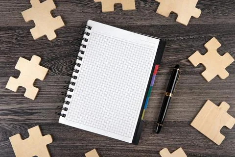 Notepad with puzzle pieces with a pen Stock Photos