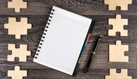 Notepad with puzzle pieces with a pen Foto stock