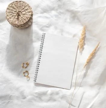 Notepad sheet, sprigs of reeds, gold earrings and wicker box Stock Photos