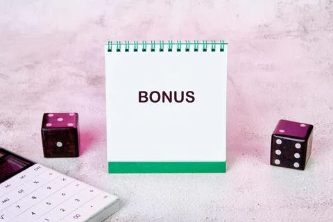 A notepad shows the word bonus while two dice and a calculator sit nearby on  스톡 사진