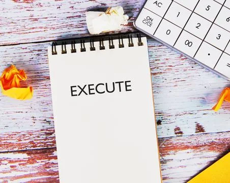A notepad shows the word execute in clear letters while a calculator and crum 스톡 사진