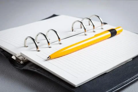 Notepad on the table with a pen, background design Stock Photos