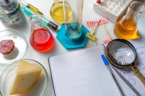 Notepad, tablets with additives E, test tubes and laboratory equipment. Food  Stock Photos