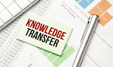 Notepad with tex KNOWLEDGE TRANSFER on the business charts and pen,business Stock Photos