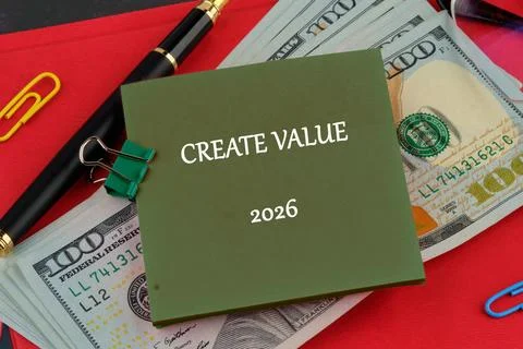 A notepad with text Create Value and the year 2026 sits on a pile of money,.. Stock Photos