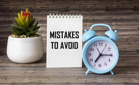 Notepad with text errors to avoid with clock and cactus on wooden backgroun.. Stock Photos
