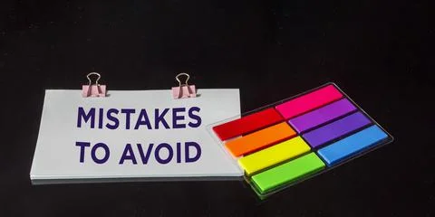 A notepad with the text Errors to Avoid lies on a black background with color 写真素材