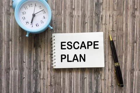 Notepad with a text escape plan and a clock with a pen on a wooden background Stock Photos