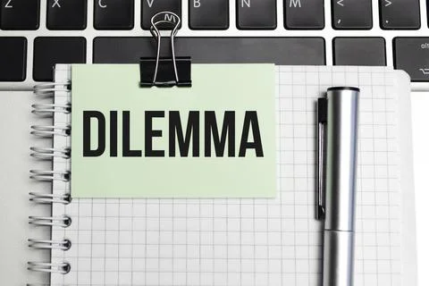 Notepad with the text on laptop DILEMMA Foto stock