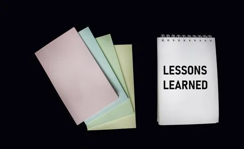 Notepad with text lessons learned on a black background. Business concept. Stock Photos