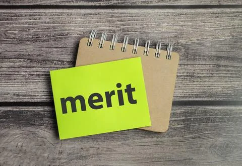 Notepad with text merit on wooden background Stock Photos