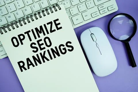 Notepad with the text "Optimize SEO Rankings" and white keyboard, wireless .. Stock Photos
